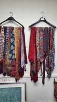 Two hangers displaying about 10 men's neck ties each with different patterns and colors.