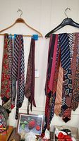 Photo showing two hangers with multiple men's neck ties of various designs including paisley, stripes, and geometric patterns.