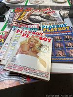 Multiple Playboy magazine issues spread out on a table, showing various cover models and dated from the 1980s to 2000s.