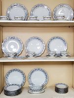 Shelves with stacks of plates and cups with saucers in Schumann Arzberg Bavaria Germany china with blue floral pattern.