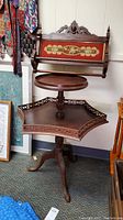 Full view of vintage tiered wooden end table and wooden towel rack with embroidery