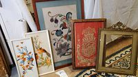 Four framed needlework and feather bird textile art pieces displayed together, showing variety of frames and textile designs.