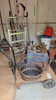 Overall lot showing dolly, cart, baskets, rope, and blue recycling bin with additional gardening pots in background.