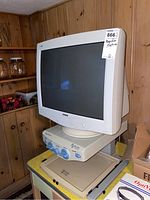 Front side view of the Philips CRT monitor mounted on the Pulse Data International magnifier machine, showing the screen and base unit with control dials.
