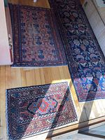 Three rugs laid out on hardwood floor showing overall sizes and patterns