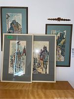 Four framed watercolour prints arranged on wall and table