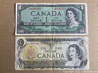 Front sides of two Canadian one-dollar banknotes: 1954 note with green hue and 1973 note with detailed crest and portrait of Queen Elizabeth II.