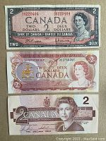 Front side of three Canadian $2 banknotes from 1954, 1974, 1986 showing portraits of Queen Elizabeth II and currency denomination