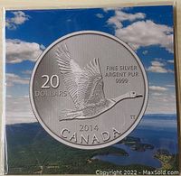 Front of packaging with image of coin showing a flying Canada Goose and inscriptions of denomination, metal purity, year and country.