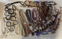 Photo showing wide range of necklaces and bracelets with various beads, faux pearls, and bangles in different colors and materials.