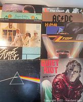 Photo displaying eleven vinyl LP albums arranged in two columns. Visible album covers include Michael Jackson, Sonny & Cher - 'All I Ever Need Is You', Cheap Trick - 'At Budokan', Chicago Transit Authority, Pink Floyd - 'The Dark Side of the Moon', Quiet Riot - 'Metal Health', ZZ Top, Def Leppard, AC/DC, The Clash and a Street Unit album.