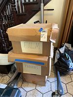 Three stacked cardboard boxes labeled 'FILM' and 'FABIANS' as well as an unlabeled bottom box.