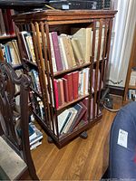 Front view showing three shelves with spindled sides and casters