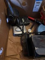 Sony Walkman cassette player among other electronics in a cardboard box.