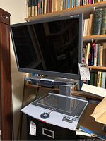 Front view of the Optelec ClearView+ electronic video magnifier showing monitor raised on stand above copyboard