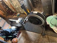 Angled side view of full rowing ergometer showing frame, flywheel housing, rail, seat and footrests