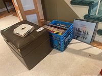 Photo showing the brown storage chest, blue plastic crate with vinyl albums inside, and a Fleetwood Mac album leaning outside.