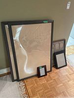 Four picture frames grouped together, three large and one small