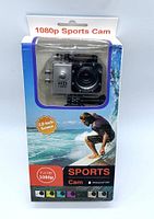 Front side of the 1080p sports camera in original packaging with water and surfing background graphics, showing 2.0-inch screen and waterproof capability to 30 meters.