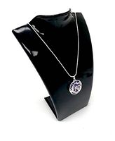 Necklace displayed on black stand featuring circular purple jade pendant with dragon and phoenix carving accented in silver tone metal.