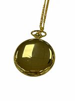 Closed gold tone pocket watch showing polished front case and top ring with chain attached.