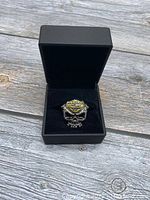 Image of men's Harley Davidson skull ring in black jewelry box on wooden surface