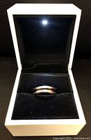 Photo of the men's titanium engagement ring in a white box showing the top view of the ring.