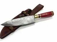 Full view of the hunting knife resting on the brown stitched leather sheath, showing the blade pattern and handle details.