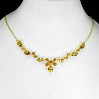 Necklace worn on display bust showing symmetrical arrangement of pear-shaped yellow stones.