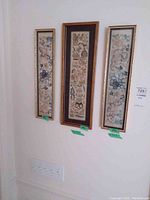 Three vertically aligned framed embroidered art panels hanging on a wall showing overall look and size comparison.