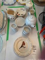 Overall set showing Bridgewater Robin plate, teapot, milk pitcher, jam plates, ramekins, and Harrods canisters.