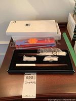 Overall image of chopsticks boxes, pack of beginner chopsticks, and black tray showing chopsticks and packaging.