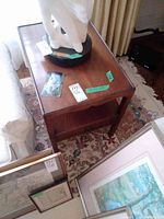 Wooden end table shown with various items on and around it, top and shelf visible.