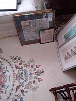 Two larger framed maps leaning against wall, one labeled ‘711 antique maps’