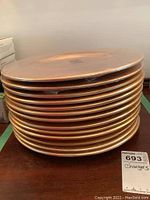 Stack of twelve copper-tone chargers showing the warm color and hammered texture.