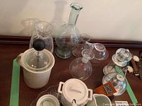 Overview of Pillivuyt white ware, Peugeot nutmeg grinder, and assorted glass decanters and serving pieces