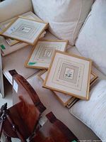 Six framed botanical prints shown stacked on a light sofa and wooden chairs, display of lot contents.