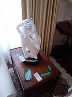 White alabaster statue of two intertwined figures on black marble base viewed from above