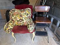 Floral upholstered armchair with cream painted wooden legs and cushioned armrests, floral fabric worn and weathered.