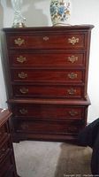Full front image of the chest of drawers showing six drawers with brass hardware.