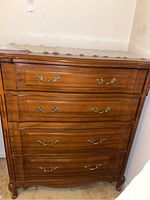 Front view of wooden chest of drawers with three drawers and brass handles