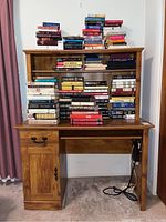 Front view of wooden desk with books on top and visible scratches on the desk surface.
