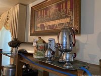 Overall view of kitchen items including bread box, coffee dispenser, ceramic canister, electric can opener, hot pot, and wall art of The Last Supper.