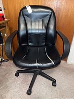 Front view of the black office chair showing the cushioned backrest and tears on the seat cushion