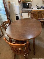 Dining table with four matching chairs around it in a kitchen setting, showing overall condition and style.