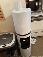 Fahrenheit branded white water cooler with black base and dispenser area, cups on top, plugged in but untested.