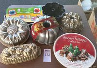 Seven assorted cake pans including detailed shaped molds and Bundt style pans with intricate designs, all displayed together.