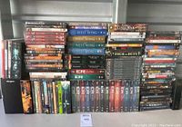 Wide view of the entire DVD lot showing stacks and rows of DVD cases including ER, Upstairs Downstairs, Lord of the Rings, The West Wing, and others.