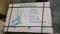 Original boxed Orbitrek exerciser model REF# OR1205, showing sealed box with straps and printed product information.