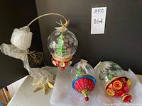 Group shot of three globes and gold star stand on white surface